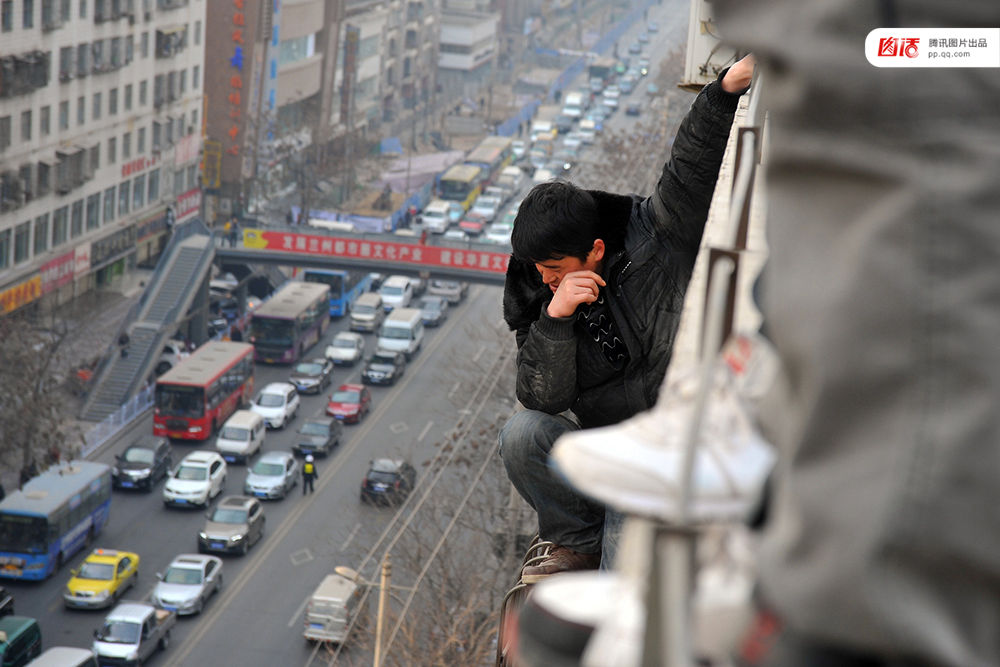 图为2014年1月3日，兰州，6名农民工为了讨薪爬上白银路一居民楼9楼平台要“跳楼”。原来，该楼4层的甘肃天安建筑机械工程公司拖欠24名工人的24万元工钱，他们讨要5个月毫无结果，便做出危险之举。后经有关部门多方协调，工人们当场拿到了18万元。于永昭/视觉中国